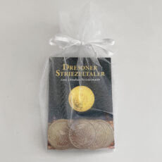 Geschenksäckchen aus cremefarbenem Organza mit 10 gemischten silberfarbenen Striezeltalern und einem goldfarbenen Taler mit dem Motiv 2023.
